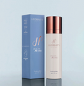 A product image featuring a bottle of Hydrinity Purifying Mist next to its packaging box. The bottle has a white body with a rose gold cap, and the box is blue with product information.