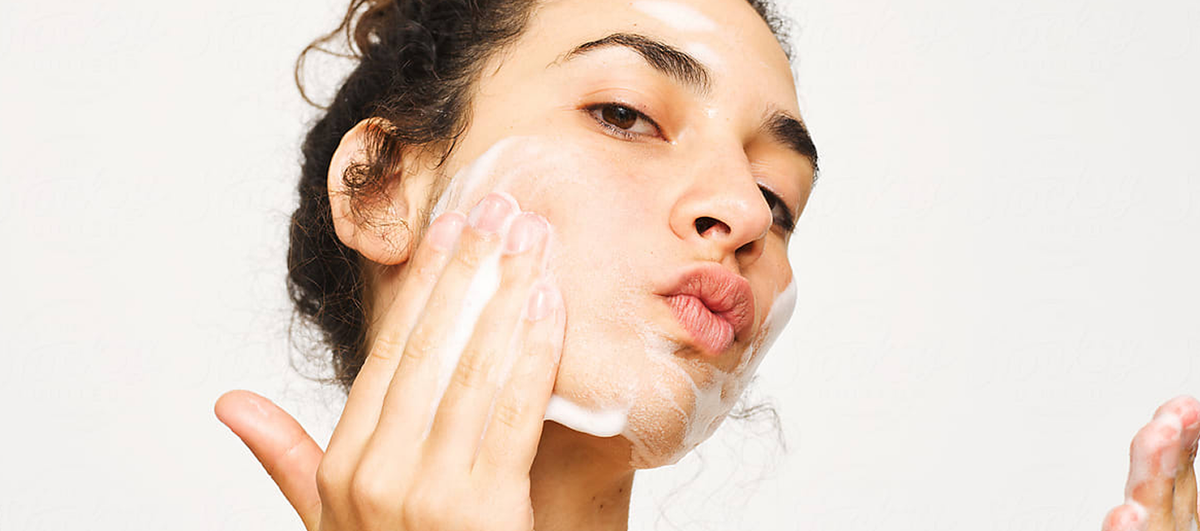 Woman washing her face with a foaming cleanser