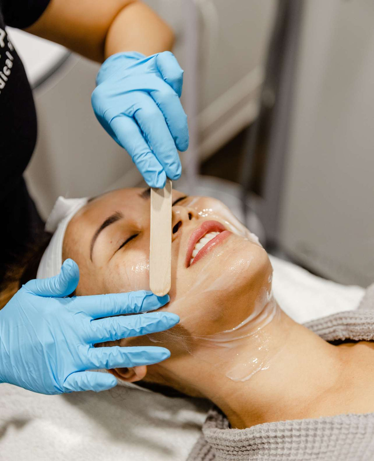 An AYA clinician performing a facial treatment on a client