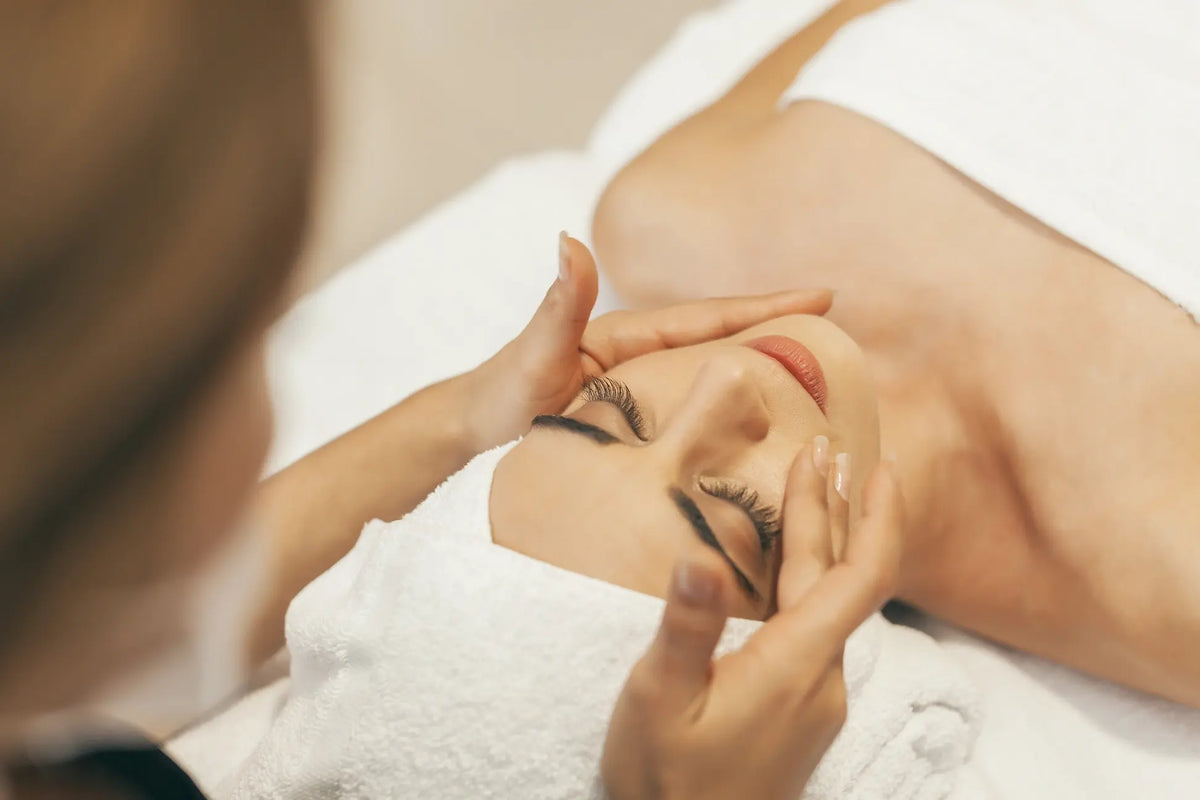 Esthetician performing a DiamondGlow facial treatment on a client