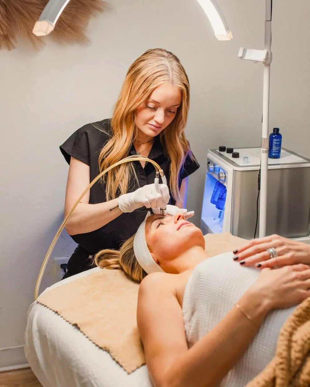 Esthetician using a diamond-tip wand during a facial treatment