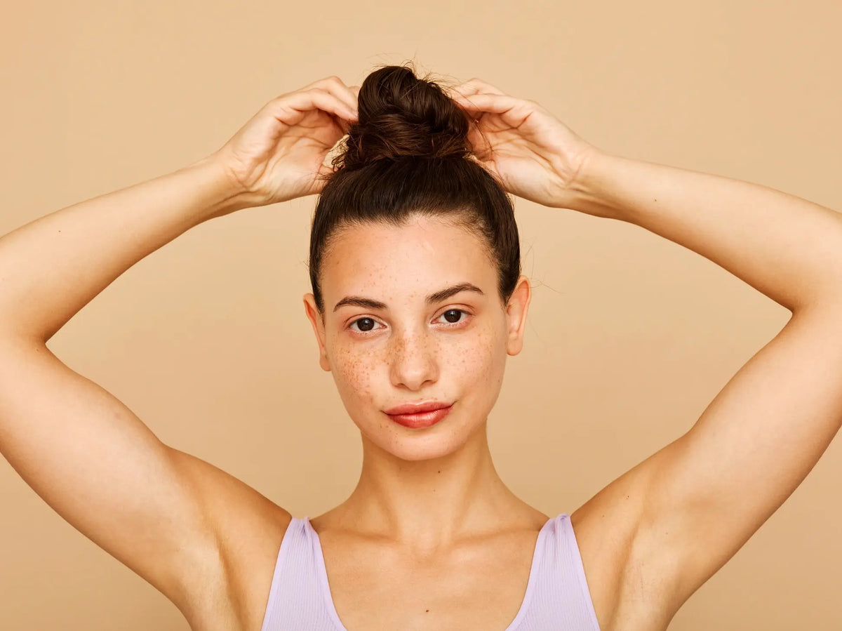 Woman with her hands above her head, showing smooth underarms