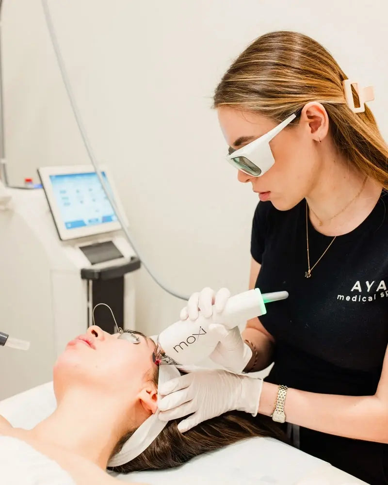 AYA Medical Spa practitioner using the Moxi laser device on a client
